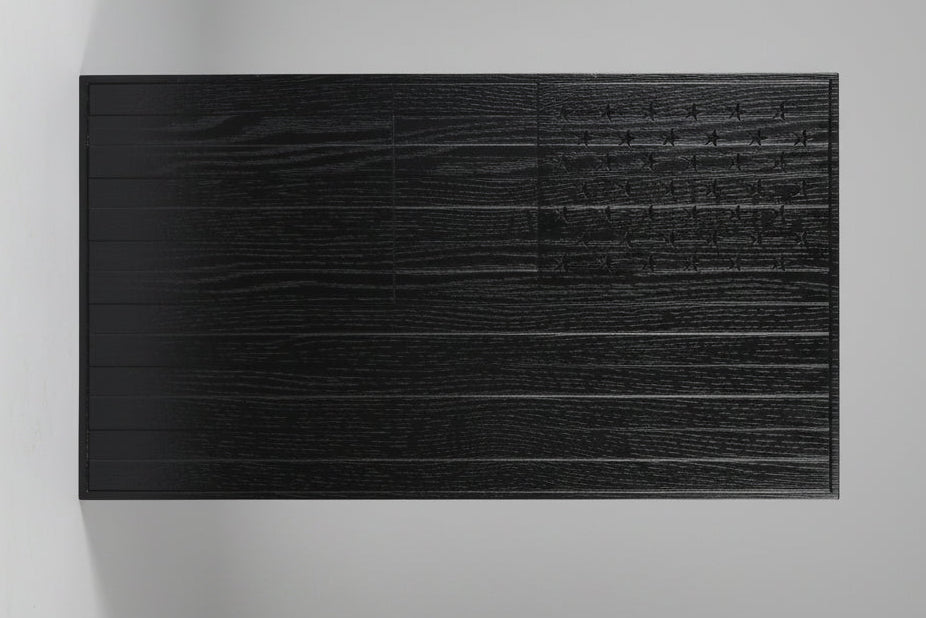 Black wooden panel with a textured surface on a beige background