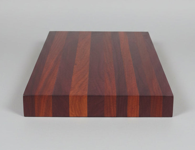 Wooden cutting board with a striped pattern on a plain background