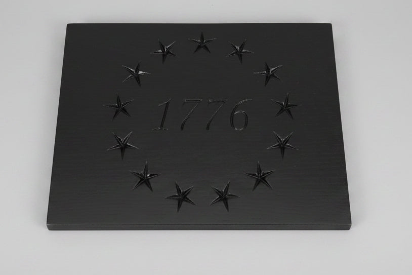 Black plaque with engraved stars and '1776' on a wooden surface with 'Woodworkers' branding.